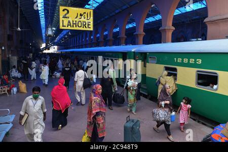 Lahore, Pakistan. 28 juillet 2020. Les Pakistanais partent pour leur ville natale et leurs villages pour célébrer Eid al-Adha avec leur amour et les membres de leur famille » à la gare, tandis que le gouvernement du Punjab a annoncé un verrouillage complet dans le cadre de l'épidémie de virus corona avant Eid-ul-Azha du 28 juillet au 5 août à Lahore. (Photo de Rana Sajid Hussain/Pacific Press) crédit: Pacific Press Media production Corp./Alay Live News Banque D'Images