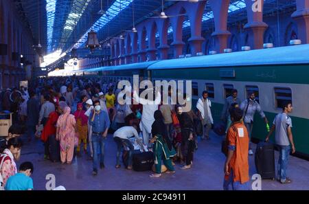 Lahore, Pakistan. 28 juillet 2020. Les Pakistanais partent pour leur ville natale et leurs villages pour célébrer Eid al-Adha avec leur amour et les membres de leur famille » à la gare, tandis que le gouvernement du Punjab a annoncé un verrouillage complet dans le cadre de l'épidémie de virus corona avant Eid-ul-Azha du 28 juillet au 5 août à Lahore. (Photo de Rana Sajid Hussain/Pacific Press) crédit: Pacific Press Media production Corp./Alay Live News Banque D'Images