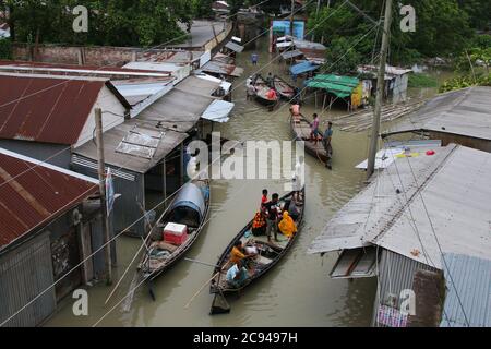 Les personnes touchées par les inondations utilisent des bateaux au cours des séquelles.un tiers du Bangladesh est sous l'eau après certaines des pluies les plus abondantes en une décennie, laissant plus de 3 millions de personnes affectées par les maisons et les routes dans les villages inondés, ont déclaré des responsables du Centre de prévision et d'alerte des inondations (FFWC). Banque D'Images