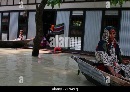 Une femme touchée par les inondations utilise un bateau au cours des séquelles.un tiers du Bangladesh est sous l'eau après certaines des pluies les plus abondantes depuis une décennie, laissant plus de 3 millions de personnes affectées par des maisons et des routes dans des villages inondés, ont déclaré des responsables du Centre de prévision et d'alerte des inondations (FFWC). Banque D'Images