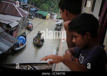 Les personnes touchées par les inondations utilisent des bateaux au cours des séquelles.un tiers du Bangladesh est sous l'eau après certaines des pluies les plus abondantes en une décennie, laissant plus de 3 millions de personnes affectées par les maisons et les routes dans les villages inondés, ont déclaré des responsables du Centre de prévision et d'alerte des inondations (FFWC). Banque D'Images