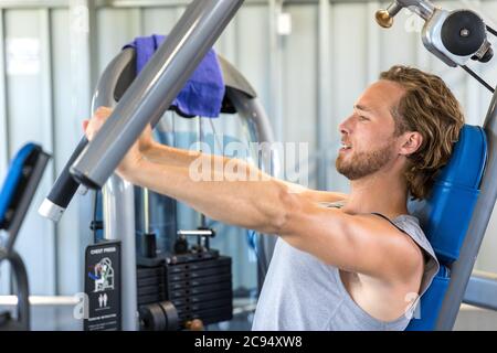 Homme s'entraînant à la salle de gym. Athlète de forme physique faisant des exercices de poitrine sur la machine de presse de banc vertical Banque D'Images