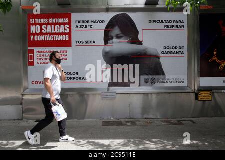 Mexico, Mexique. 28 juillet 2020. MEXICO, MEXIQUE - JUILLET 28 : un homme porte un masque facial lorsqu'il marche devant une affiche de séjour à la maison pour tenter d'empêcher la propagation de la nouvelle pandémie Covid-19 le 28 juillet 2020 à Mexico, Mexique crédit : l'accès photo/Alamy Live News Banque D'Images