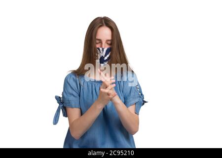 Une jeune femme aux cheveux longs vêtue d'une robe bleue. Isolé sur fond blanc dans un masque médical, se lave les mains, le concept d'hygiène au moment du virus et de la quarantaine Banque D'Images