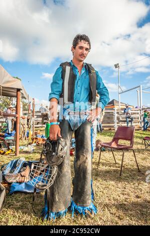 Un cow-boy représente un portrait, un casque à la main, alors qu'il se prépare mentalement pour sa prochaine promenade à cheval au Mt Garnet Rodeo dans le Queensland, en Australie. Banque D'Images