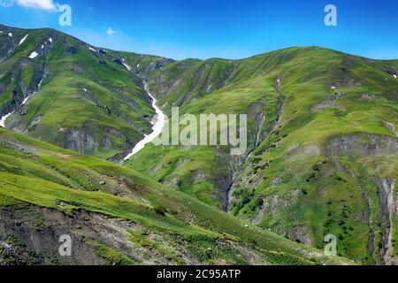 Paysage d'été idyllique avec sentier de randonnée dans les montagnes avec de beaux pâturages de montagne vert frais, ciel bleu et nuages. Tian-Shan, Kirghizistan. Banque D'Images