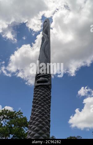 Immense totem en bois calédonien neuf typique. Parc des grandes Fougères, Nouvelle-Calédonie. Le ciel est bleu Banque D'Images