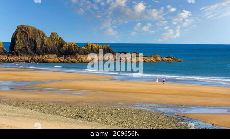 Bunmahon, Comté de Waterford, République d'Irlande. Eire. Les gens qui marchent sur la plage de Bunmahon. Bunmahon est situé sur la Côte du cuivre, qui est un G de l'UNESCO Banque D'Images