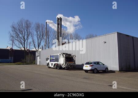 Bâtiment d'entrepôt industriel néerlandais avec derrière lui la cheminée de fumée de l'usine de recyclage des déchets Huisvuilcentrale Alkmaar, HVC, camion à ordures Banque D'Images