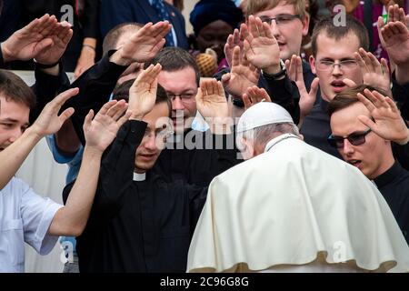 Le pape François prie avec un groupe de jeunes prêtres à la fin de son audience générale hebdomadaire sur la place Saint-Pierre au Vatican. Banque D'Images