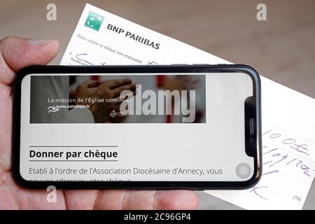 Collecte de fonds sur un smartphone pour l'église catholique. France. Banque D'Images