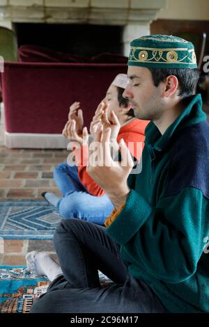 Frères priant à la maison pendant le ramadan en France. Banque D'Images