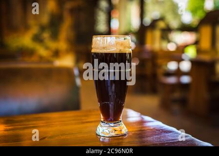 Verre avec des types sombres de bières artisanales sur un bar en bois. Verres de différents types de bière pression dans un pub Banque D'Images