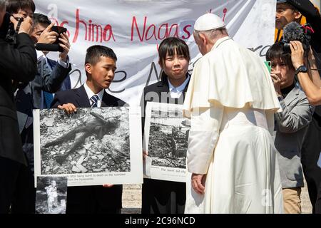 Le pape François rencontre des adolescents japonais Uchiyama Koshiro, de Nagasaki, et Matsuda Koharu, d'Hiroshima, tous deux en 16, avec des photos historiques de c Banque D'Images