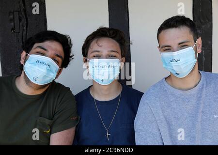 Jeune homme musulman, chrétien et juif portant des masques de protection en France. Banque D'Images