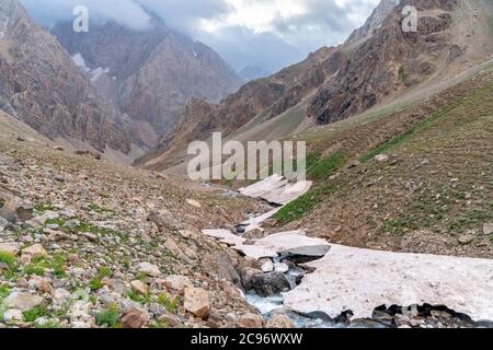 La belle vue sur le glacier gelé et la rivière Kaznok propre au sommet de Zmeya dans les montagnes de Fann au Tadjikistan Banque D'Images