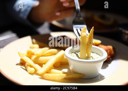 Frites sur une fourchette en sauce à côté de la viande hachée. Banque D'Images