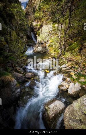 Petit ruisseau rapidement entre les rochers dans une journée ensoleillée Banque D'Images