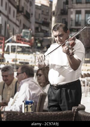 Cáceres, ESPAGNE - 12 avril 2010 : un musicien joue du violon sur la Plaza Mayor de Caceres, en divertissant les touristes avec leur musique. Banque D'Images