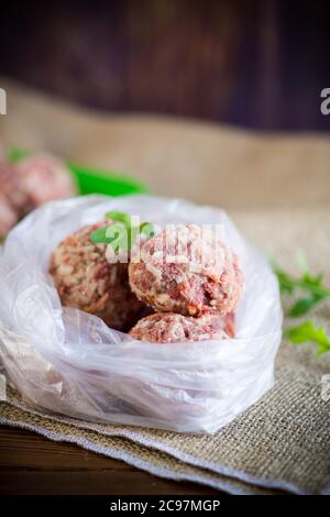 boulettes de viande crues congelées de bœuf et de porc avec carottes et riz dans un sac de cellophane Banque D'Images