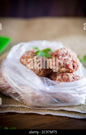 boulettes de viande crues congelées de bœuf et de porc avec carottes et riz dans un sac de cellophane Banque D'Images