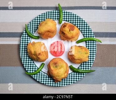 Purée de boules de pommes de terre enrobées de farine de pois chiches et légèrement frites. Cuisine indienne et encas très populaires. Également appelé batata ama. Banque D'Images