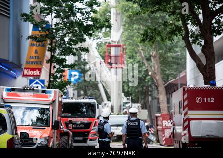 29 juillet 2020, Rhénanie-du-Nord-Westphalie, Düsseldorf: Des policiers se trouvent dans une rue en face d'un bâtiment dans l'arrière-cour où une maison s'est effondrée. Des parties d'un bâtiment s'étaient effondrées lundi lors des travaux de construction dans le centre-ville de Düsseldorf. Un ouvrier de construction manquant a été trouvé mort, et la recherche continue pour un deuxième ouvrier de construction photo: Fabian Strauch/dpa Banque D'Images