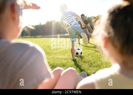 Père et fils jouant au football dans le jardin Banque D'Images