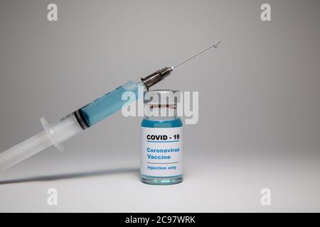 Petite bouteille de vaccin (flacon) avec une étiquette portant la mention « Covid - 19 Corona virus Vaccine injection Only » et une seringue médicale avec un vaccin d Banque D'Images