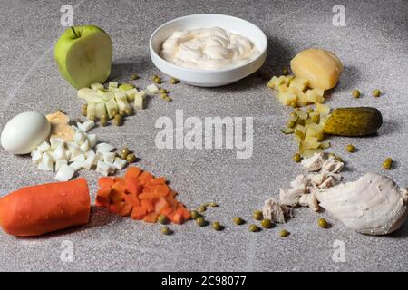 Ingrédients pour salade Olivier. Filet de poulet bouilli, pois verts, pommes de terre bouillies, carottes bouillies, cornichons marinés, mayonnaise, pommes vertes et poussins Banque D'Images