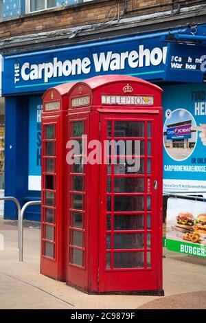 Les anciennes boîtes téléphoniques rouges originales sont gérées par BT devant un magasin d'entrepôt de téléphonie automobile qui vient d'être fermé en raison de l'évolution de l'industrie des communications téléphoniques. Bournemouth Angleterre Royaume-Uni (120) Banque D'Images