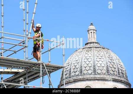 Londres, Royaume-Uni. 29 juillet 2020. Le dôme de la National Gallery se dresse derrière un ouvrier de construction qui enlève un échafaudage autour de l'artiste Heather Phillipson 'THE END', qui sera bientôt dévoilé au public comme la nouvelle œuvre du quatrième Plinth à Trafalgar Square. LA FIN montrera un tourbillon géant de réplique de crème fouettée surmontée d'une cerise, d'une mouche et d'un drone. Son drone transmettra une alimentation en direct de la place qui peut être regardé sur un site Web dédié. L'installation, prévue à l'origine pour le 26 mars 2020, mais reportée en raison de la pandémie du coronavirus, restera exposée pour la prochaine année deux yea Banque D'Images