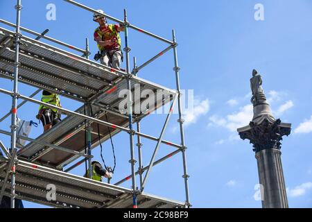 Londres, Royaume-Uni. 29 juillet 2020. La colonne de Nelson se dresse derrière des ouvriers de construction qui déchillaient des échafaudages autour de l'artiste Heather Phillipson « THE END », qui sera bientôt dévoilé au public comme la nouvelle œuvre du quatrième Plinth à Trafalgar Square. LA FIN montrera un tourbillon géant de réplique de crème fouettée surmontée d'une cerise, d'une mouche et d'un drone. Son drone transmettra une alimentation en direct de la place qui peut être regardé sur un site Web dédié. L'installation, prévue à l'origine pour le 26 mars 2020, mais reportée en raison de la pandémie du coronavirus, restera exposée pendant les deux prochaines années. Crédit Banque D'Images