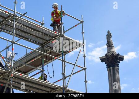 Londres, Royaume-Uni. 29 juillet 2020. La colonne de Nelson se dresse derrière des ouvriers de construction qui déchillaient des échafaudages autour de l'artiste Heather Phillipson « THE END », qui sera bientôt dévoilé au public comme la nouvelle œuvre du quatrième Plinth à Trafalgar Square. LA FIN montrera un tourbillon géant de réplique de crème fouettée surmontée d'une cerise, d'une mouche et d'un drone. Son drone transmettra une alimentation en direct de la place qui peut être regardé sur un site Web dédié. L'installation, prévue à l'origine pour le 26 mars 2020, mais reportée en raison de la pandémie du coronavirus, restera exposée pendant les deux prochaines années. Crédit Banque D'Images