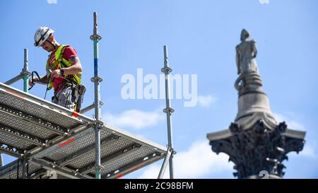Londres, Royaume-Uni. 29 juillet 2020. La colonne de Nelson se dresse derrière un ouvrier de construction qui enlève un échafaudage autour de l'artiste Heather Phillipson 'THE END', qui sera bientôt dévoilé au public comme la nouvelle œuvre du quatrième Plinth à Trafalgar Square. LA FIN montrera un tourbillon géant de réplique de crème fouettée surmontée d'une cerise, d'une mouche et d'un drone. Son drone transmettra une alimentation en direct de la place qui peut être regardé sur un site Web dédié. L'installation, prévue à l'origine pour le 26 mars 2020, mais reportée en raison de la pandémie du coronavirus, restera exposée pendant les deux prochaines années. De la Banque D'Images
