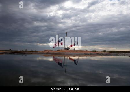 Midland, Texas, États-Unis. 29 juillet 2020. Les drapeaux du Texas et des États-Unis ornent un site de forage au sud-est de Midland, au Texas, où le président américain Donald Trump (non présenté) se rendra le 29 juillet 2020 à la suite d'une collecte de fonds et d'une table ronde à Odessa, une ville voisine. Trump devrait signer des proclamations préconisant une dépendance accrue à la production de pétrole du bassin Permien crédit : Bob Daemmrich/ZUMA Wire/Alamy Live News Banque D'Images