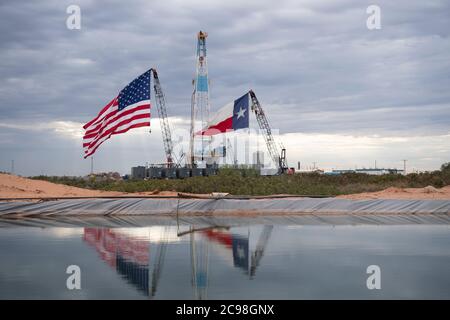 Midland, Texas, États-Unis. 29 juillet 2020. Les drapeaux du Texas et des États-Unis ornent un site de forage au sud-est de Midland, au Texas, où le président américain Donald Trump (non présenté) se rendra le 29 juillet 2020 à la suite d'une collecte de fonds et d'une table ronde à Odessa, une ville voisine. Trump devrait signer des proclamations préconisant une dépendance accrue à la production de pétrole du bassin Permien crédit : Bob Daemmrich/ZUMA Wire/Alamy Live News Banque D'Images