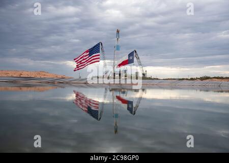 Midland, Texas, États-Unis. 29 juillet 2020. Les drapeaux du Texas et des États-Unis ornent un site de forage au sud-est de Midland, au Texas, où le président américain Donald Trump (non présenté) se rendra le 29 juillet 2020 à la suite d'une collecte de fonds et d'une table ronde à Odessa, une ville voisine. Trump devrait signer des proclamations préconisant une dépendance accrue à la production de pétrole du bassin Permien crédit : Bob Daemmrich/ZUMA Wire/Alamy Live News Banque D'Images