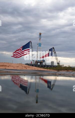 Midland, Texas, États-Unis. 29 juillet 2020. Les drapeaux du Texas et des États-Unis ornent un site de forage au sud-est de Midland, au Texas, où le président américain Donald Trump (non présenté) se rendra le 29 juillet 2020 à la suite d'une collecte de fonds et d'une table ronde à Odessa, une ville voisine. Trump devrait signer des proclamations préconisant une dépendance accrue à la production de pétrole du bassin Permien crédit : Bob Daemmrich/ZUMA Wire/Alamy Live News Banque D'Images