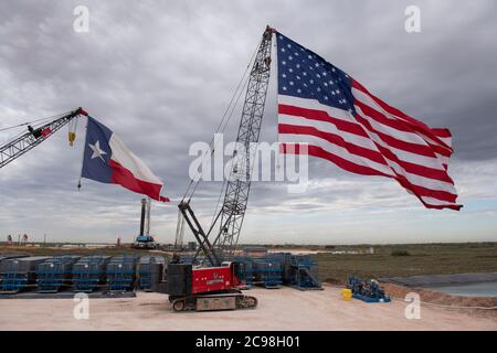 Midland, Texas, États-Unis. 29 juillet 2020. Les drapeaux du Texas et des États-Unis ornent un site de forage au sud-est de Midland, au Texas, où le président américain Donald Trump (non présenté) se rendra le 29 juillet 2020 à la suite d'une collecte de fonds et d'une table ronde à Odessa, une ville voisine. Trump devrait signer des proclamations préconisant une dépendance accrue à la production de pétrole du bassin Permien crédit : Bob Daemmrich/ZUMA Wire/Alamy Live News Banque D'Images