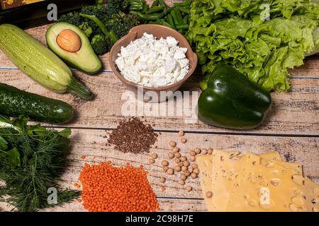 Un ensemble de produits nutritionnels appropriés: Avocat, pois chiches, fromage cottage, légumes verts, lentilles, huile d'olive, graines de lin Banque D'Images