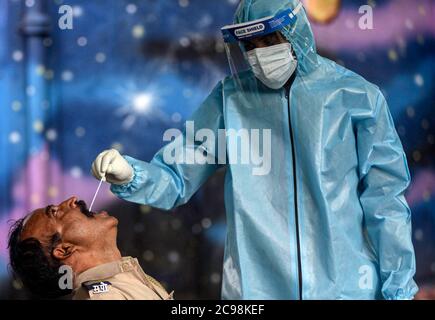 Mumbai, Inde. 29 juillet 2020. Un agent de santé prélève un échantillon d'écouvillon dans la gorge d'un homme lors d'un dépistage médical pour le COVID-19 à Mumbai, Inde, le 29 juillet 2020. Le compte COVID-19 de l'Inde a dépassé mercredi les 1.5 millions, atteignant 1,531,669, a annoncé le ministère fédéral de la Santé. Credit: STR/Xinhua/Alay Live News Banque D'Images