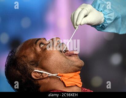 Mumbai, Inde. 29 juillet 2020. Un agent de santé prélève un échantillon d'écouvillon dans la gorge d'un homme lors d'un dépistage médical pour le COVID-19 à Mumbai, Inde, le 29 juillet 2020. Le compte COVID-19 de l'Inde a dépassé mercredi les 1.5 millions, atteignant 1,531,669, a annoncé le ministère fédéral de la Santé. Credit: STR/Xinhua/Alay Live News Banque D'Images