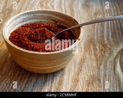 Bol en bois avec sucre brun gros plan. La cuillère est remplie de sucre. Gros plan des ustensiles sur une table en bois Banque D'Images
