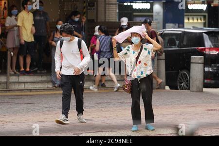 (200729) -- HONG KONG, le 29 juillet 2020 (Xinhua) -- des personnes portant un masque facial sont vues dans WAN Chai, dans le sud de la Chine Hong Kong, le 29 juillet 2020. Le Centre pour la protection de la santé (CHP) de Hong Kong a signalé mercredi 118 autres cas confirmés de COVID-19, ce qui porte le nombre total de cas de COVID-19 à Hong Kong au-dessus de 3,000. Ce fut le huitième jour de droit où les cas supplémentaires quotidiens à Hong Kong ont dépassé les 100. (Xinhua/Lui Siu Wai) Banque D'Images