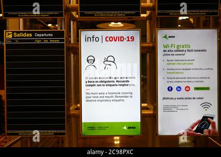 28 juillet 2020, aéroport de Barajas, Madrid, Espagne : panneau d'information Covid-19 et tableau de départ de vol vide dans le salon de départ du bâtiment terminal 4S de l'aéroport de Barajas. Un nombre réduit de vols est actuellement en service entre les pays européens après le verrouillage pour contrôler le coronavirus Covid-19, et les gouvernements ont mis en place un système de ponts aériens pour faciliter les voyages et le tourisme. L'Espagne a connu un certain nombre de nouvelles épidémies ces derniers jours, ce qui a incité le gouvernement britannique à annoncer que les personnes qui rentrent au Royaume-Uni depuis l'Espagne devraient mettre en quarantaine pendant 14 jours à leur arrivée. Banque D'Images