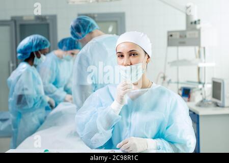 Jeune infirmière fatiguée en chapeau prenant le masque facial. Gros plan photo.Job, concept d'occupation Banque D'Images