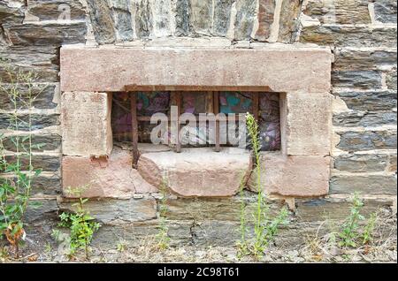 Courtepointe farcie dans une petite fenêtre, grille en fer rouillé, cadre en pierre, près du sol, vieux, inhabituel, Europe; Zell, Allemagne Banque D'Images