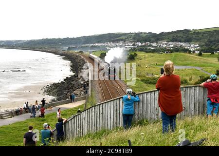 Llanelli, pays de Galles. 29 juillet 2020. Les gens regardent le moteur à vapeur Britannia 70000 se rendre le long de la magnifique ligne côtière rurale de Llanelli, tandis que la locomotive traverse le sud du pays de Galles. Depuis son retrait du service en 1966, les moteurs ont été préservés et sont maintenant la propriété de la Locomotive Royal Scot et de General Trust et transportent des passagers sur des circuits de lignes principales à travers le Royaume-Uni crédit : Robert Melen/Alay Live News Banque D'Images