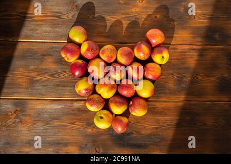 nectarines disposées en forme de coeur sur un fond en bois Banque D'Images